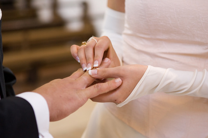 Braut streift Bräutigam den Ring über